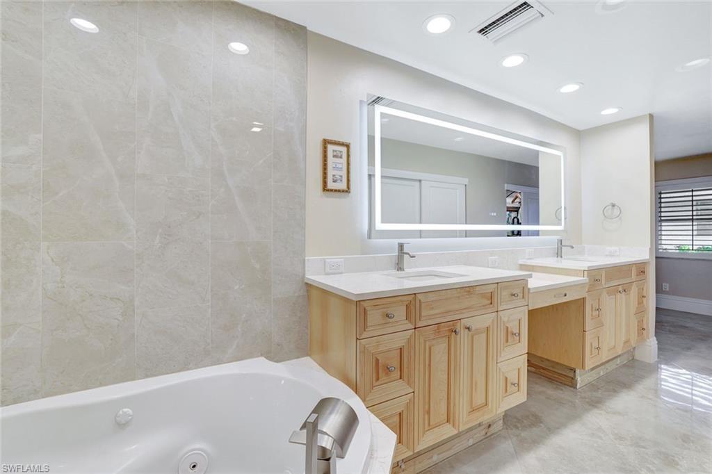 Bathroom with vanity and a bath