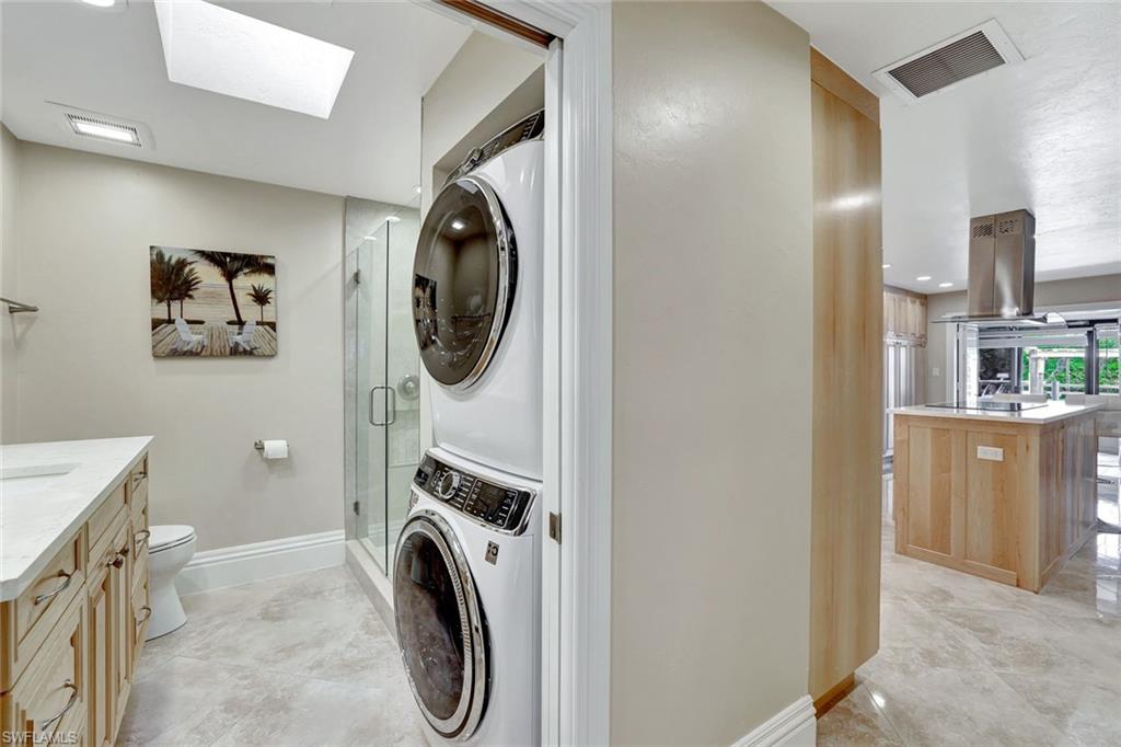 Laundry area featuring a skylight and stacked washer and clothes dryer
