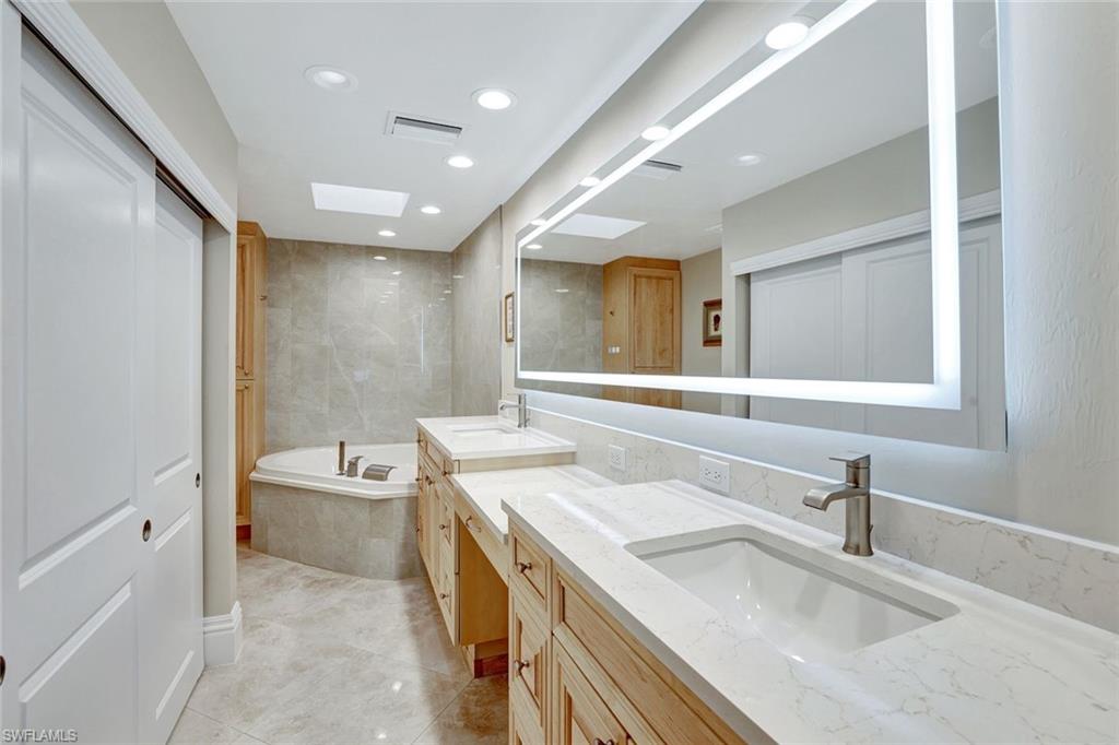 Bathroom featuring vanity and tiled bath