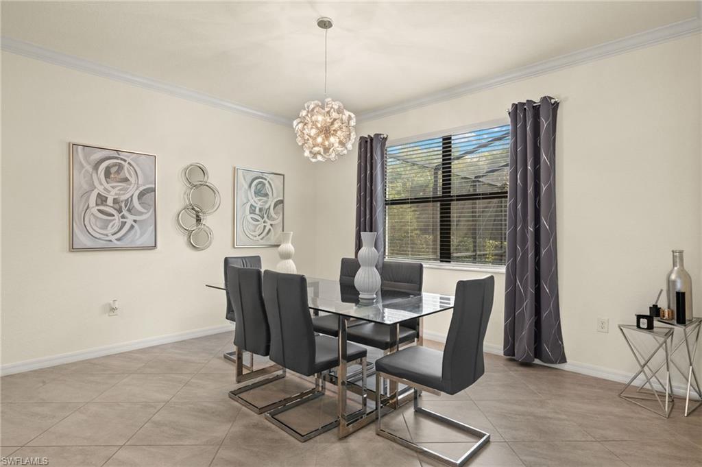 Tiled dining space featuring a chandelier and crown molding