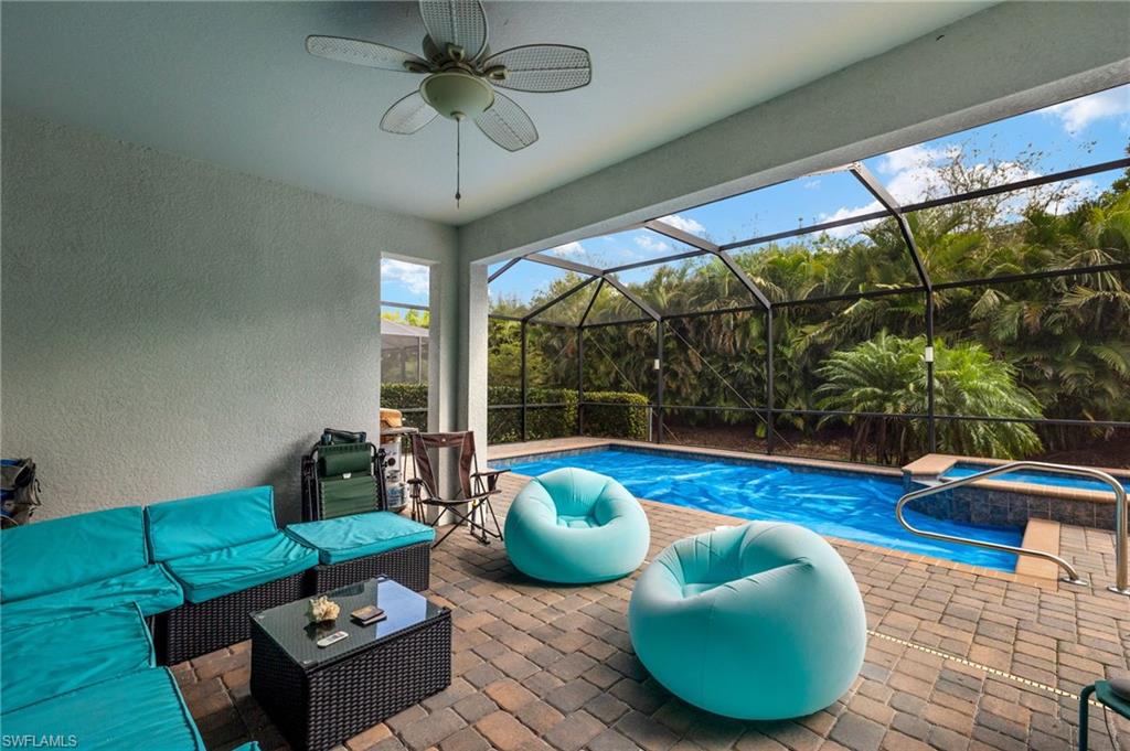 View of swimming pool featuring a patio, a lanai, outdoor lounge area, and ceiling fan