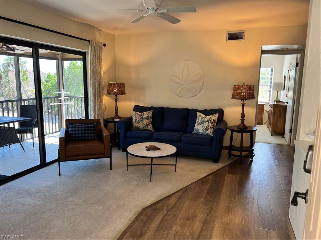 Living room featuring wood finished floors, a ceiling fan, and visible vents