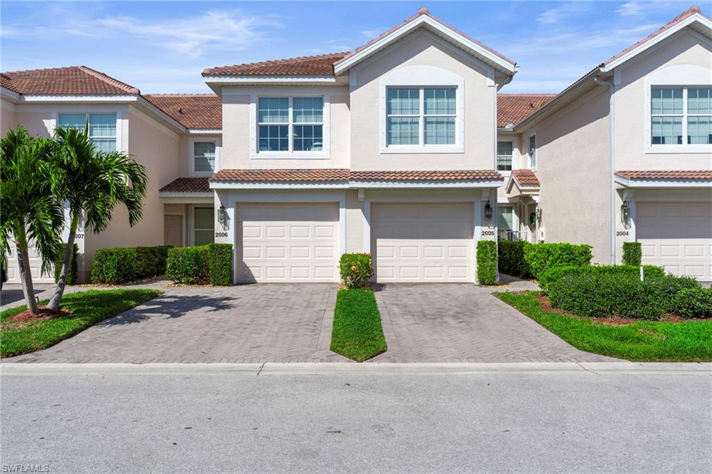 First Floor Carriage Style Home featuring decorative driveway, an attached garage, a tile roof, and stucco siding
