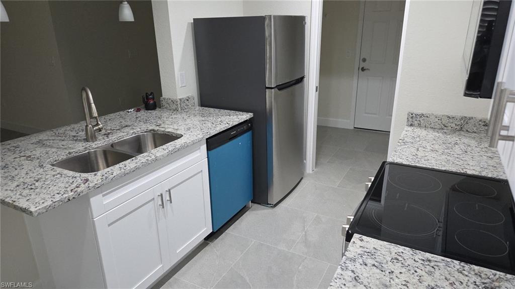 Kitchen with white cabinetry, light stone countertops, electric stove, dishwashing machine, and a peninsula