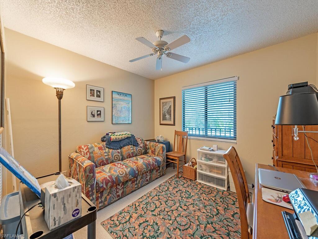 Office space featuring carpet, ceiling fan, and a textured ceiling