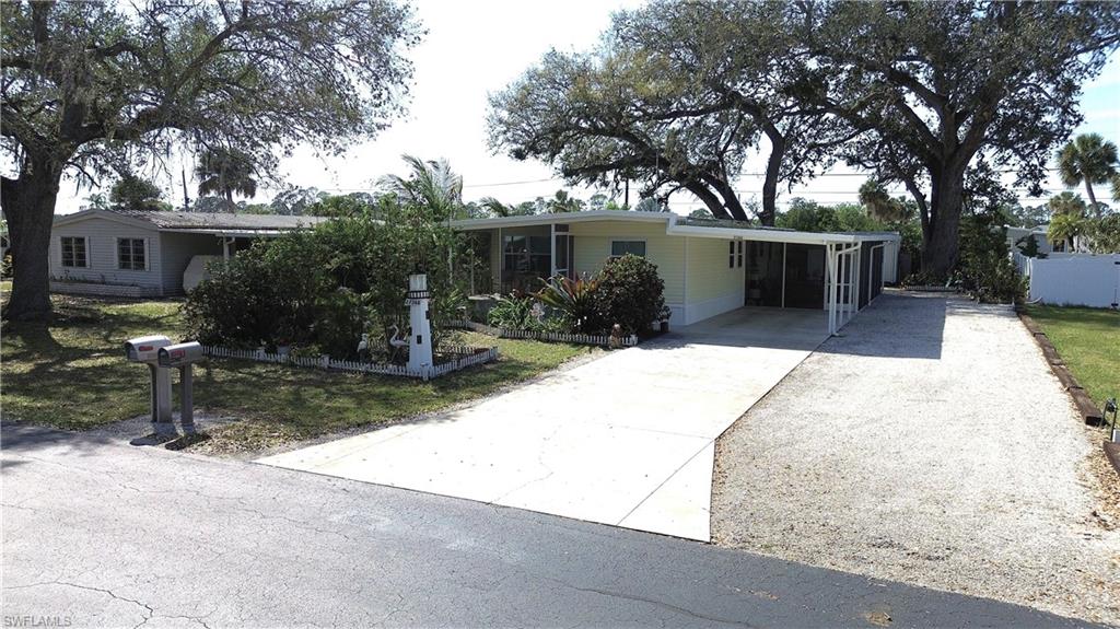 View of front of home with concrete driveway and a carport