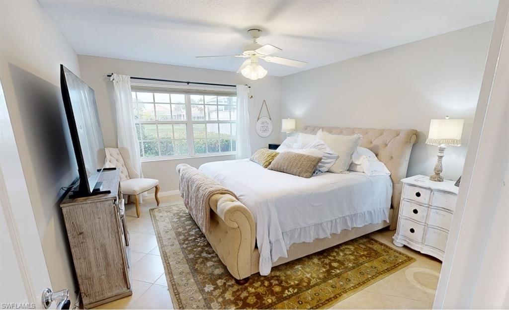 Bedroom with light tile patterned floors and ceiling fan