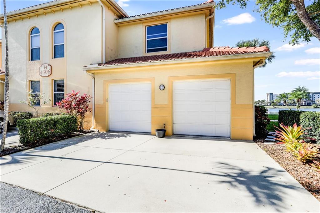 Mediterranean / spanish house featuring concrete driveway, a tiled roof, an attached garage, and stucco siding