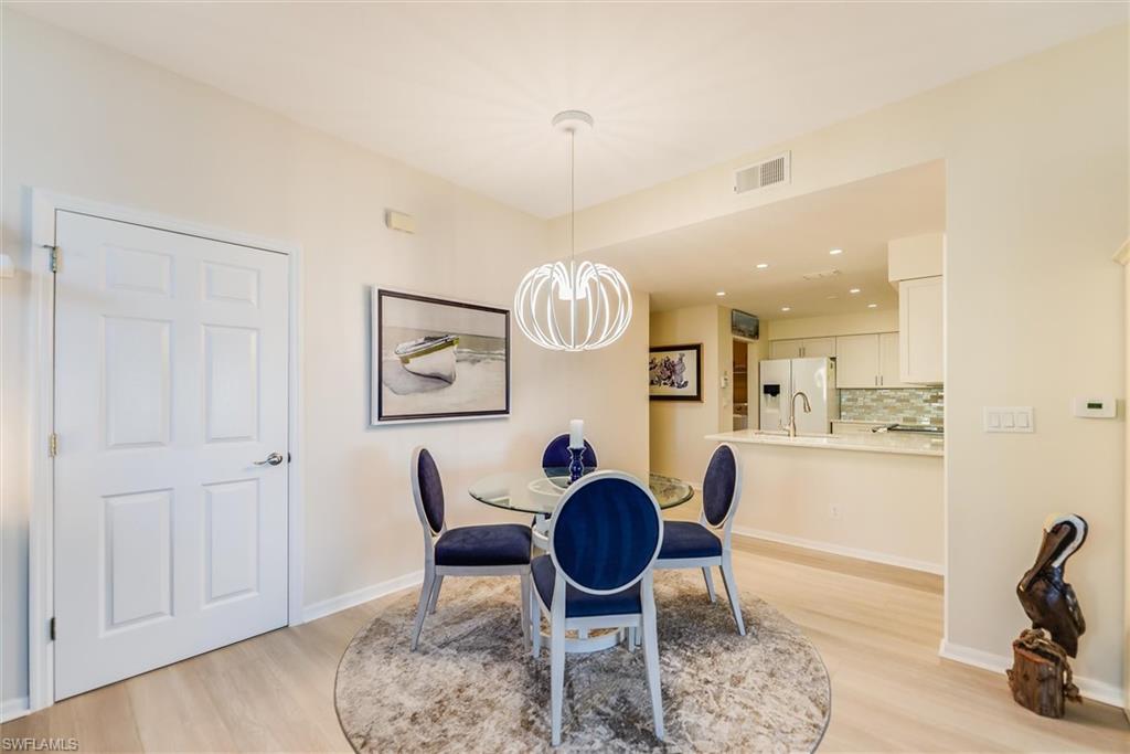 Dining room featuring light wood finished floors, baseboards, visible vents, a notable chandelier, and recessed lighting