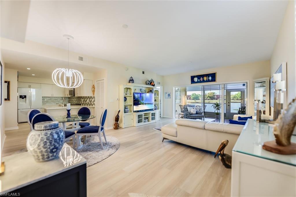 Living room featuring a chandelier, baseboards, visible vents, and light wood-style floors
