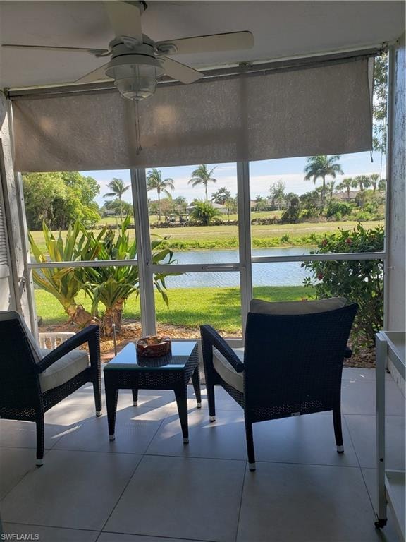 Sunroom with a water view, a ceiling fan, and a healthy amount of sunlight