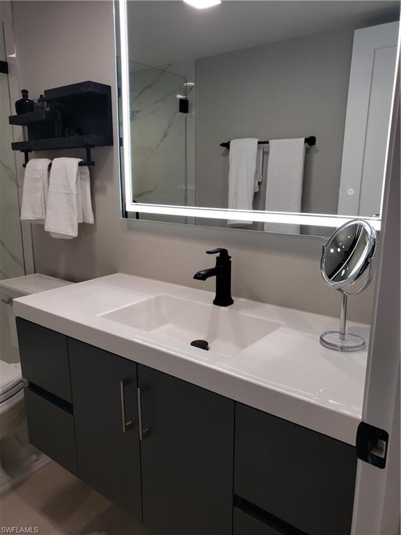Full bath with toilet, walk in shower, and vanity