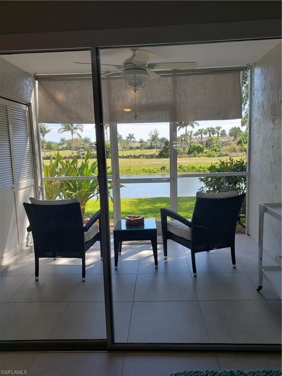 Sunroom / solarium with a water view and ceiling fan