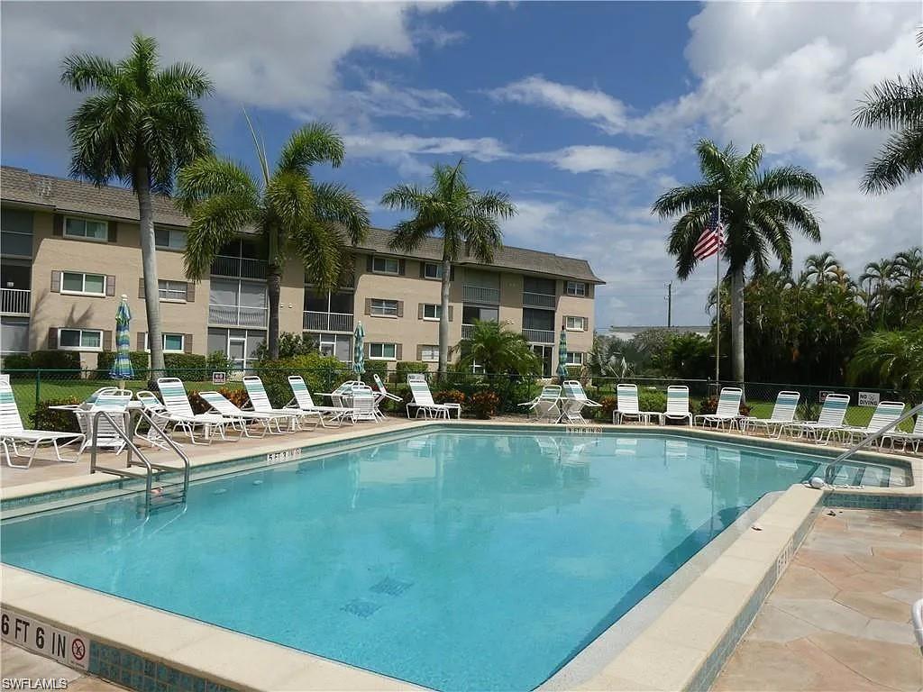 Community pool featuring a patio and fence