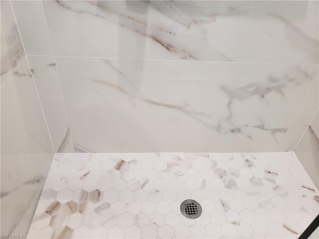 custom designed shower with large format tile on walls and custom glass and door