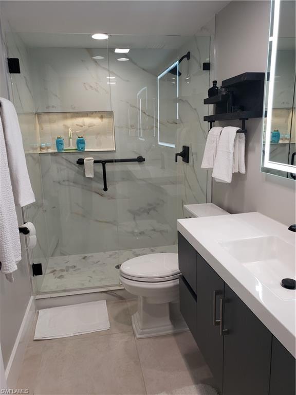 Bathroom features floating vanity with lighted mirror and large format tile on shower wall and custom glass and door