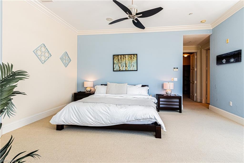 Bedroom with light carpet, a ceiling fan, baseboards, and crown molding