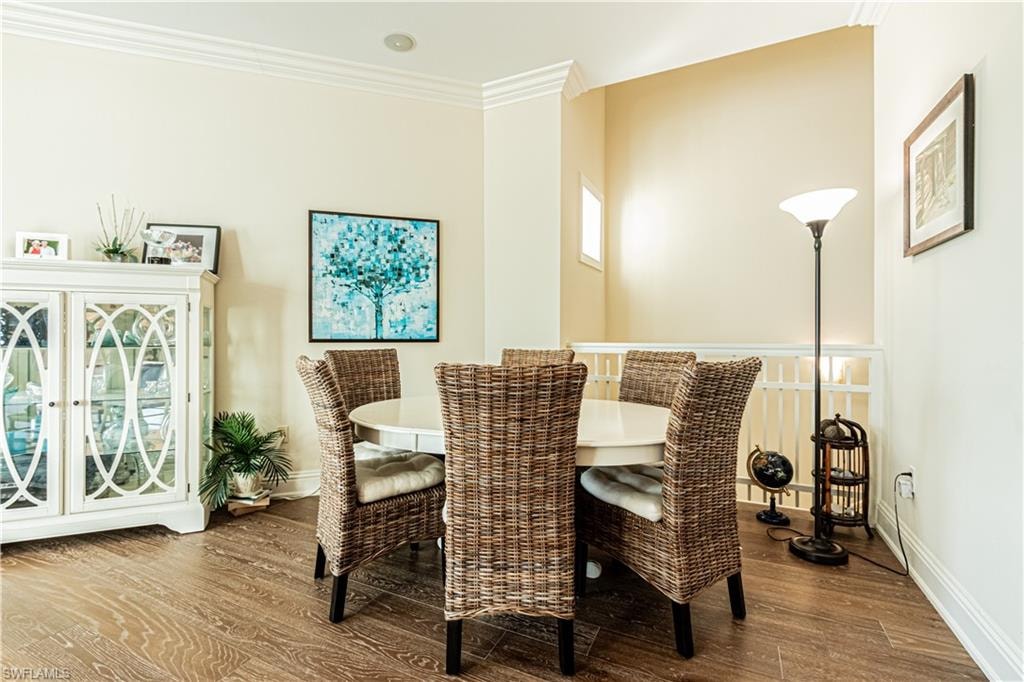 Dining room with ornamental molding, baseboards, and wood finished floors
