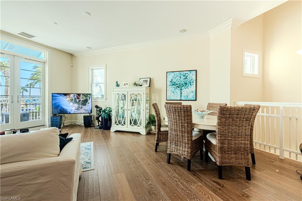 Dining room featuring crown molding, visible vents, and wood finished floors