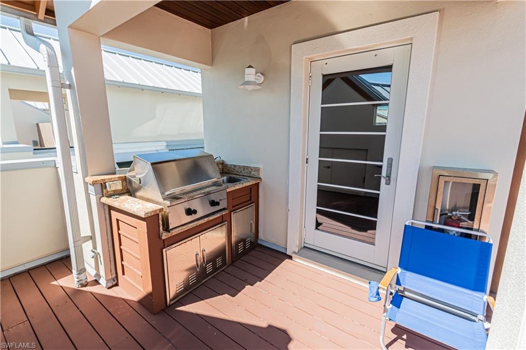 Deck with an outdoor kitchen and a grill