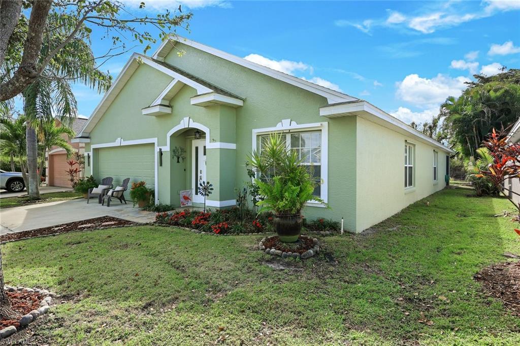 Ranch-style home featuring a garage, concrete driveway, a front yard, and stucco siding