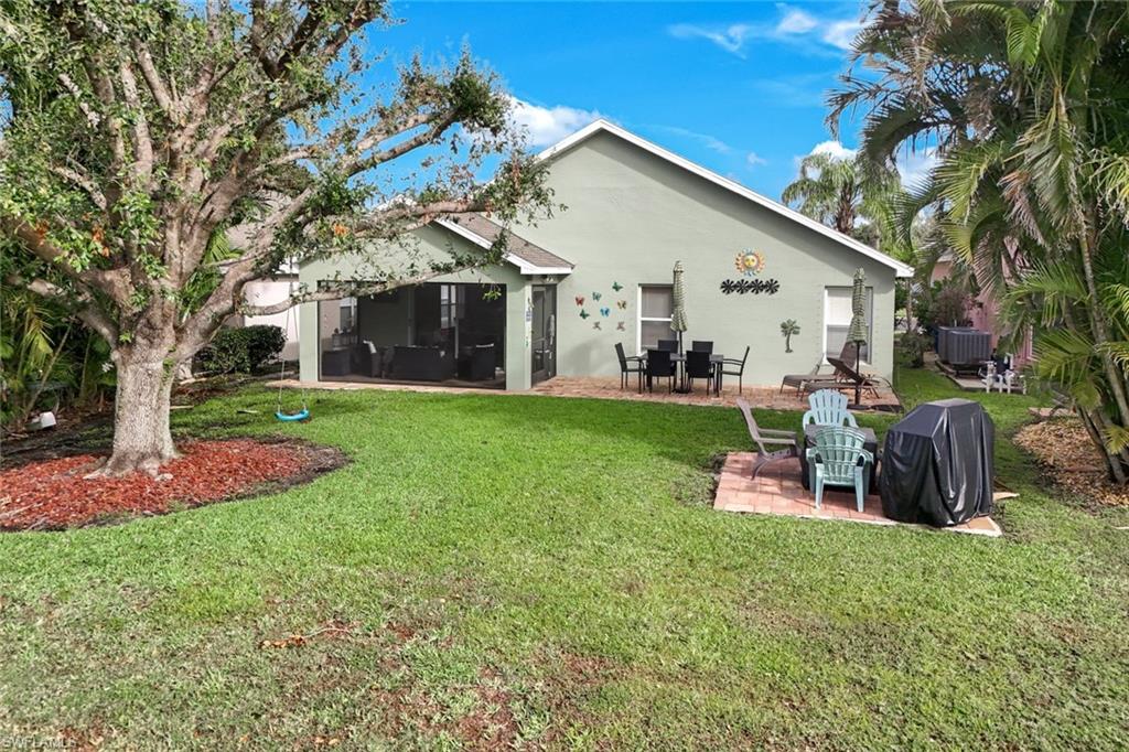 Back of property featuring a yard, central AC unit, a patio area, and stucco siding
