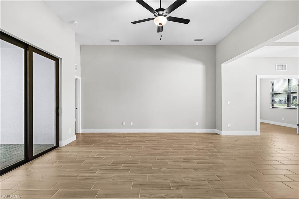 Unfurnished room with wood finish floors and a ceiling fan