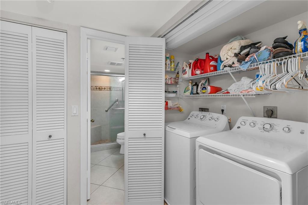 Laundry area with laundry area, visible vents, washer and clothes dryer, and light tile patterned floors