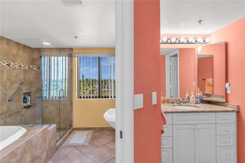 Full bathroom featuring tiled bath, tile patterned flooring, visible vents, vanity, and a shower stall