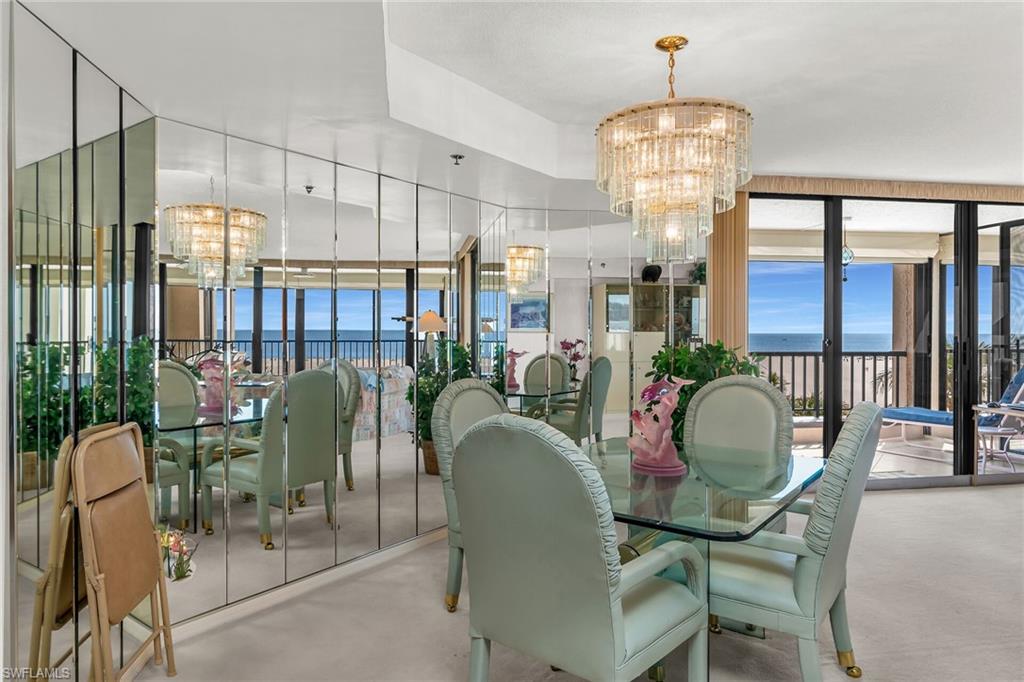 Dining room with concrete flooring, a water view, plenty of natural light, and an inviting chandelier