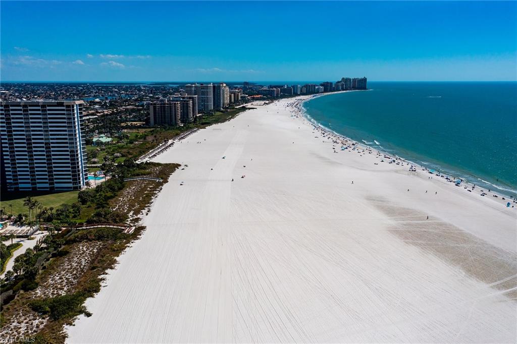 Drone / aerial view with a water view, a view of city, and a view of the beach