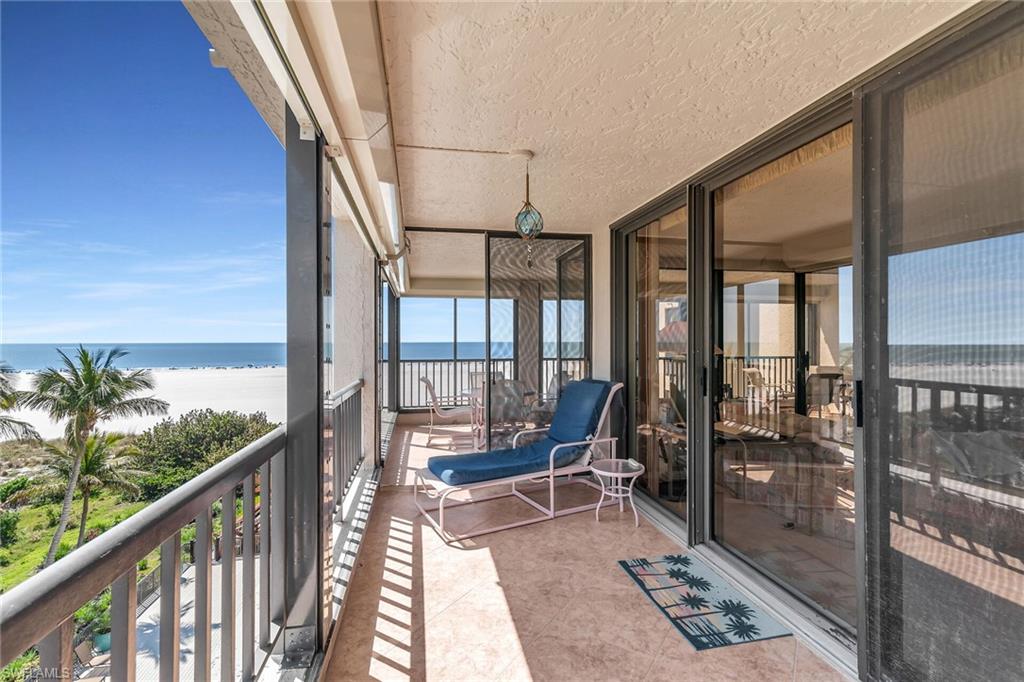 Balcony featuring a water view and a view of the beach