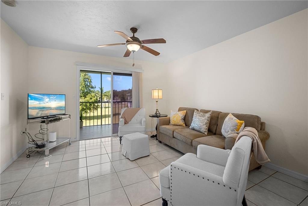 Living area featuring light tile patterned flooring and a ceiling fan
