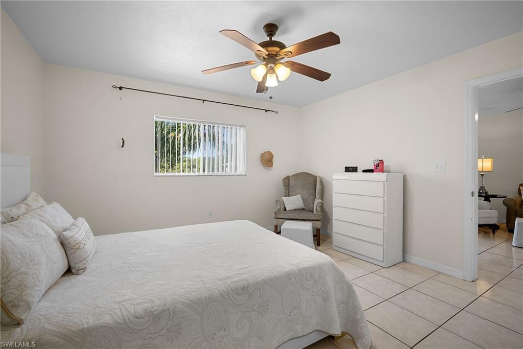 Bedroom with a ceiling fan and light tile patterned floors