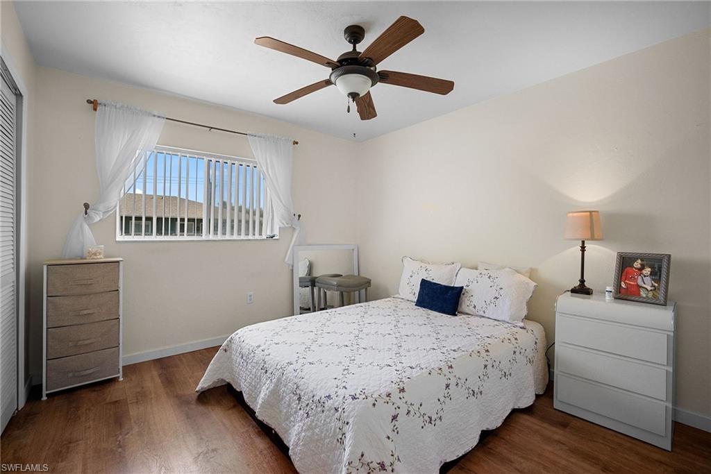 Bedroom featuring a ceiling fan, dark wood finished floors, and a closet