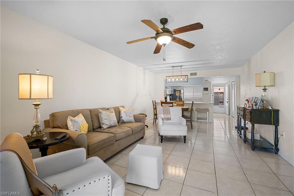 Living room with tile patterned floors and a ceiling fan