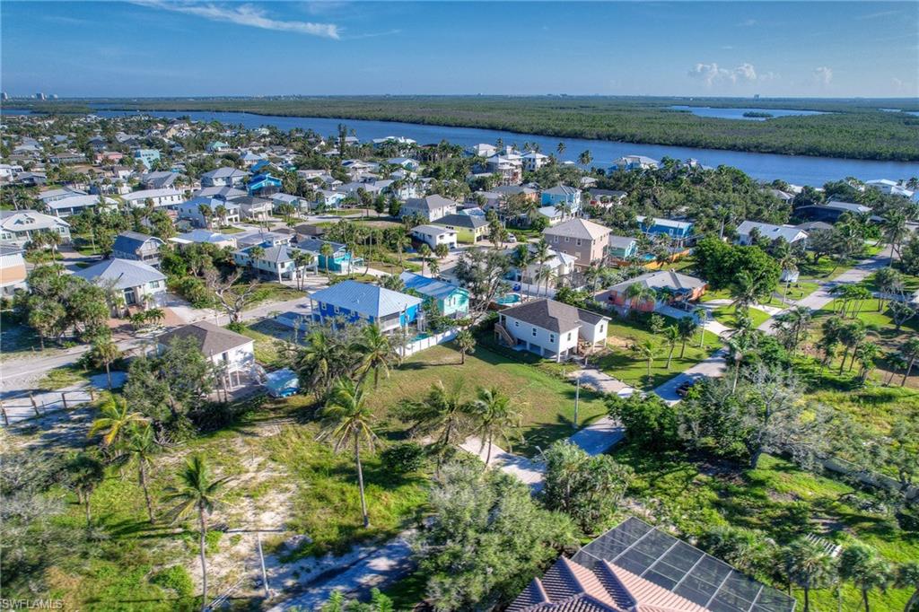 Aerial view of property and surrounding area featuring a large body of water and nearby suburban area