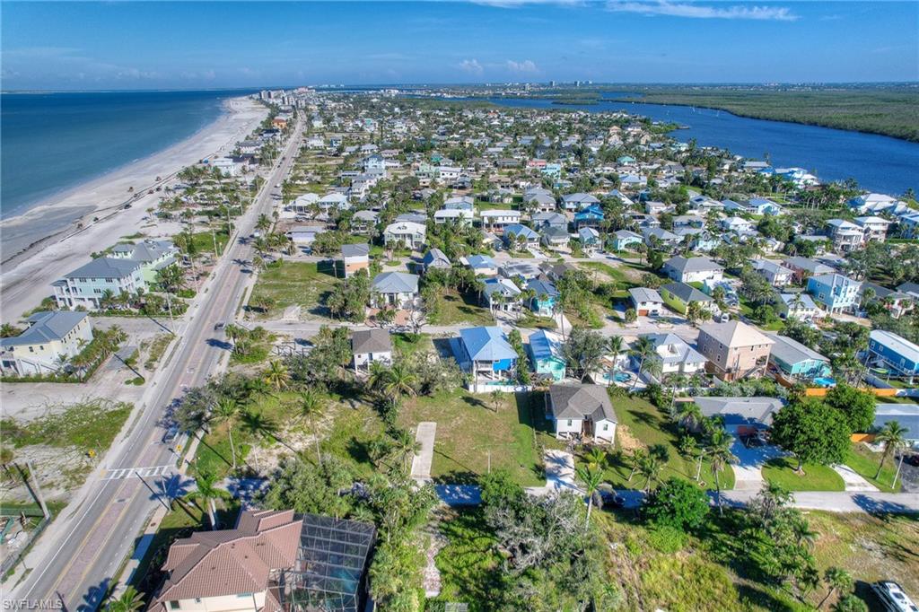 Aerial view of property and surrounding area featuring unending shoreline and nearby suburban area