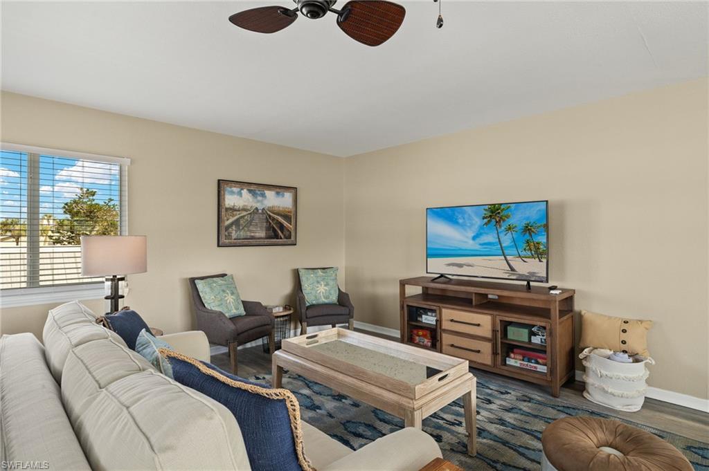Living room featuring ceiling fan, baseboards, and wood finished floors