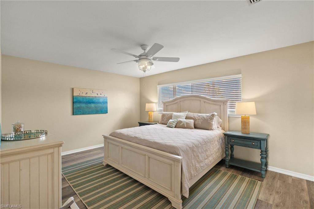 Bedroom featuring dark wood-type flooring, baseboards, and a ceiling fan