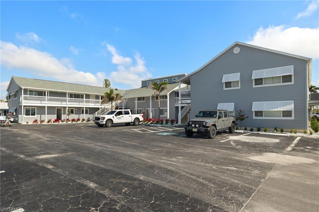 View of building exterior with uncovered parking