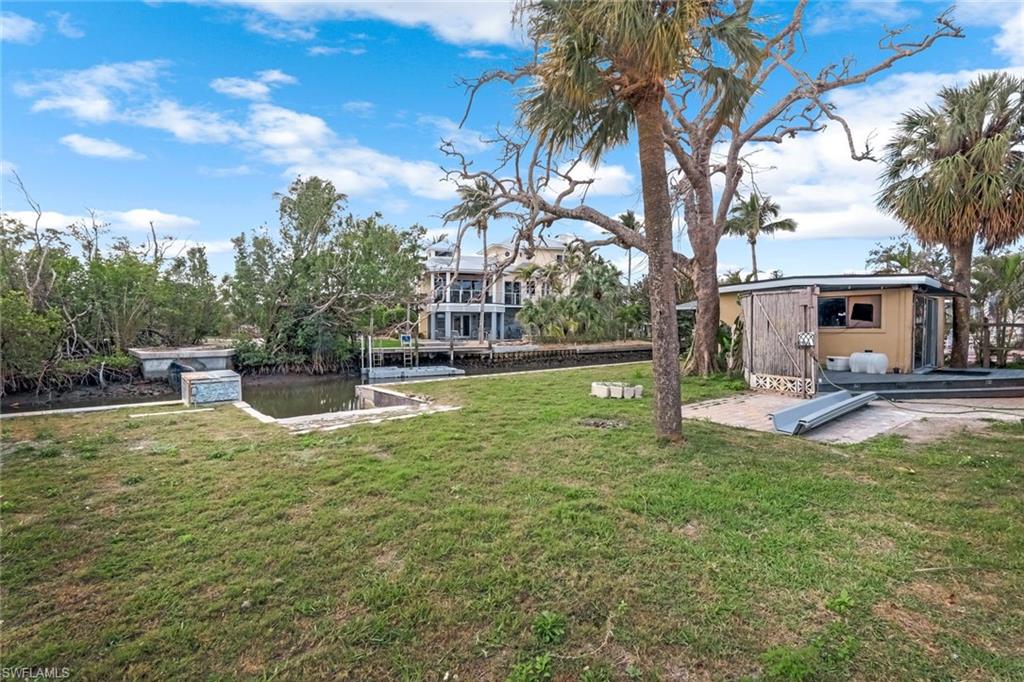 View of yard with a water view, boat ramp, and a workshop