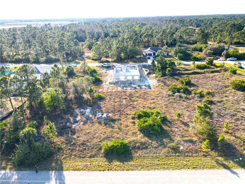 Birds eye view of property with a wooded view