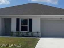 View of front of house with driveway, an attached garage, a front yard, and stucco siding