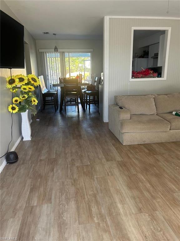 Living area featuring baseboards, visible vents, and wood finished floors
