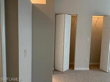 Unfurnished bedroom with baseboards and light colored carpet