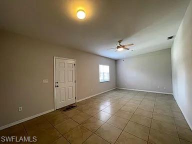 Spare room featuring tile patterned flooring, baseboards, and ceiling fan