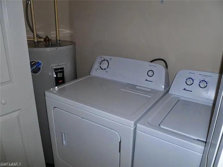 Laundry room featuring washer and dryer and electric water heater