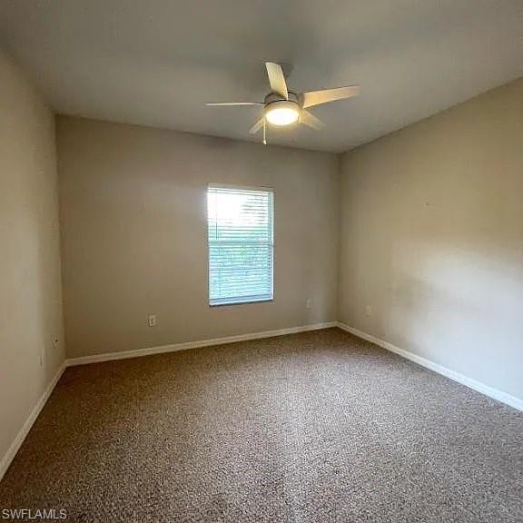 Empty room with a ceiling fan and baseboards