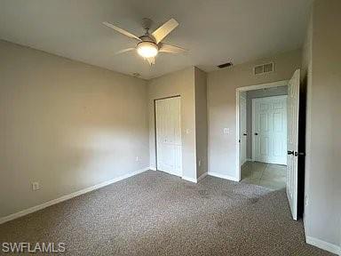 Unfurnished bedroom featuring visible vents, ceiling fan, baseboards, carpet flooring, and a closet